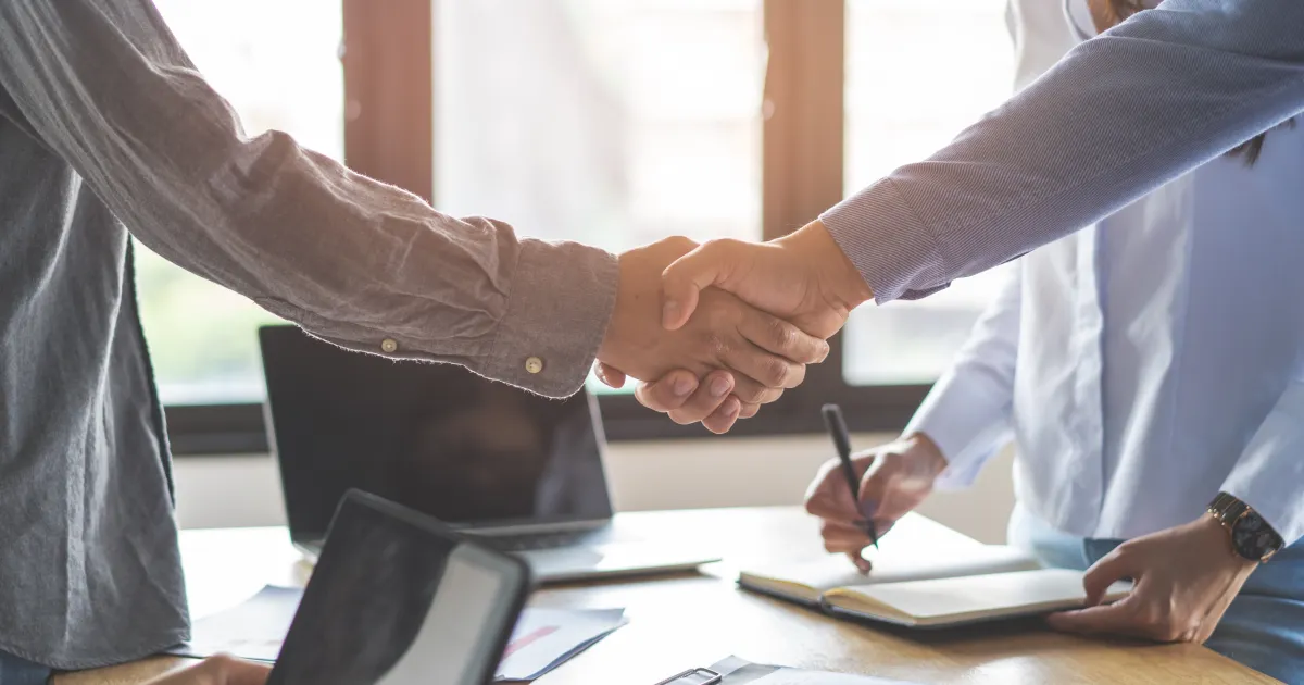 Two people shaking hands in an office