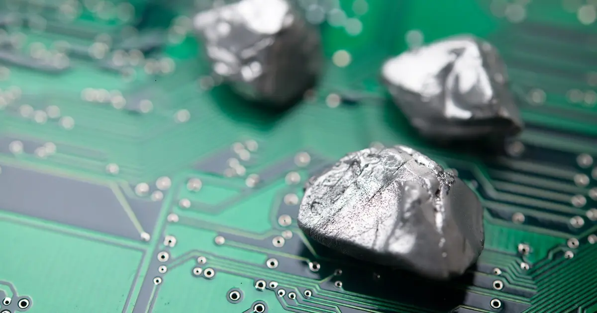 Mineral rare earth element on green electronic circuit board background copy space. US vs China chip war, tech war, semiconductor industry concept. China curbs on exports of rare earth element to US.